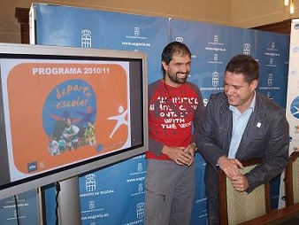 Darío Pérez Brunicardi y Javier Arranz, junto al cartel promocional del deporte escolar en la ciudad de Segovia