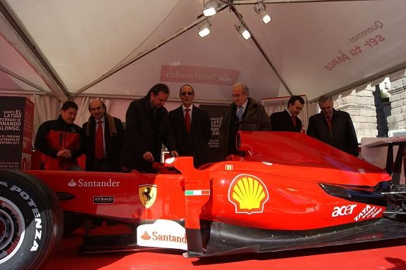 Javier Arranz y Pedro Arahuetes, entre otros, observan el Ferrari que se expone en la Plaza del Azoguejo