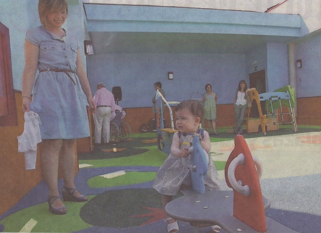 Noa, hija del concejal de Deportes, Javier Arranz, juega en el patio de la guardería con uno de los aparatos de recreo ante la atenta mirada de María, su madre